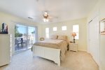 The large master bedroom has a queen bed, flat screen tv, and access to the balcony.